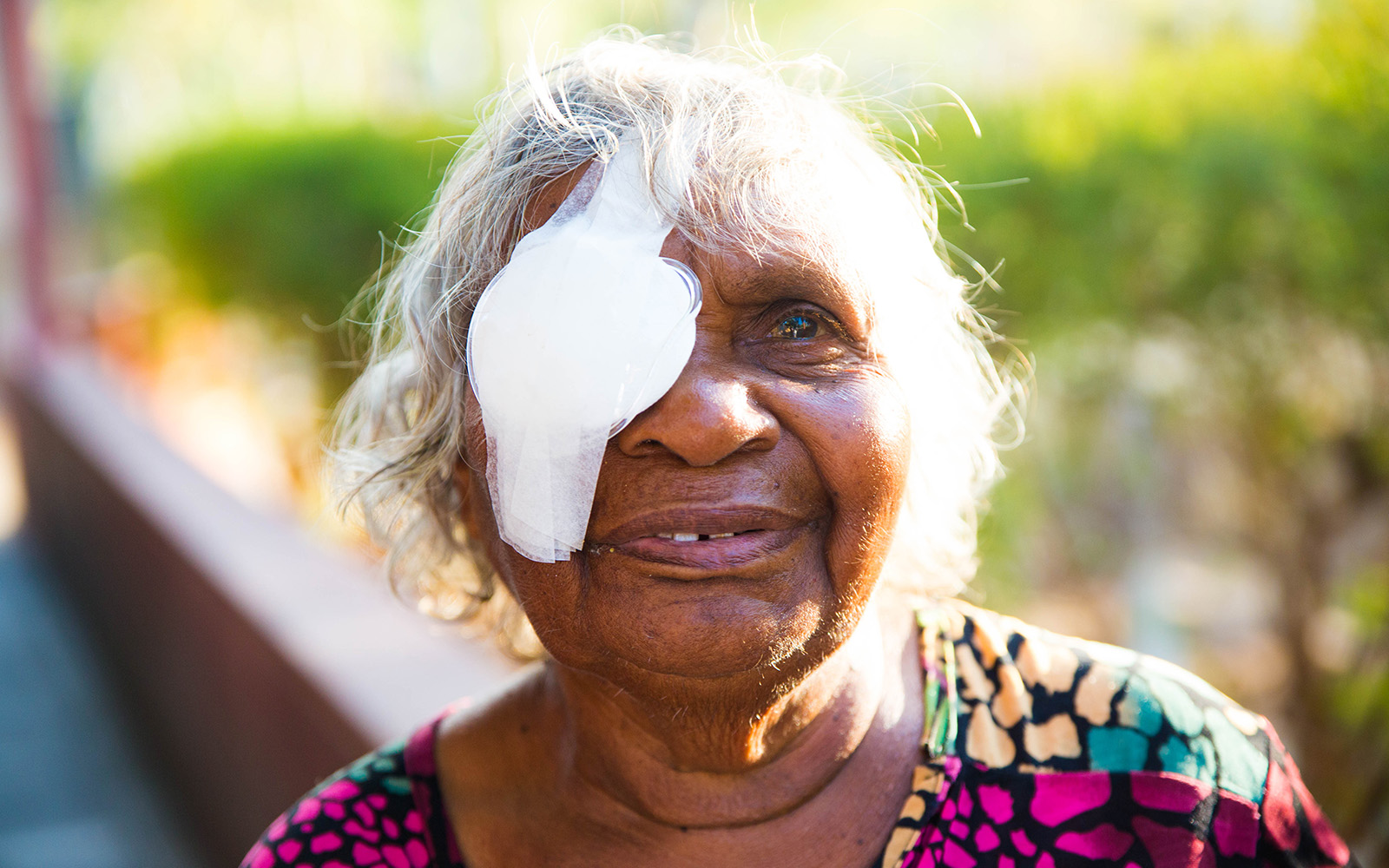 gray haired old woman with her left eye covered with gauze