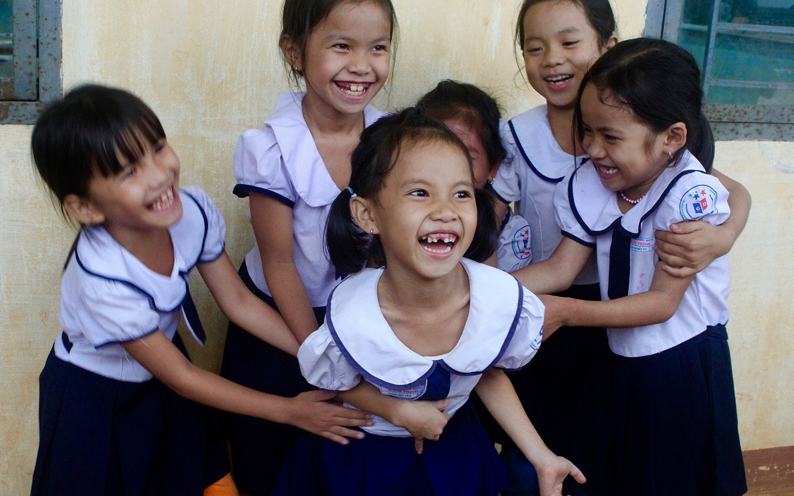 little girls in their school uniform teasing each other