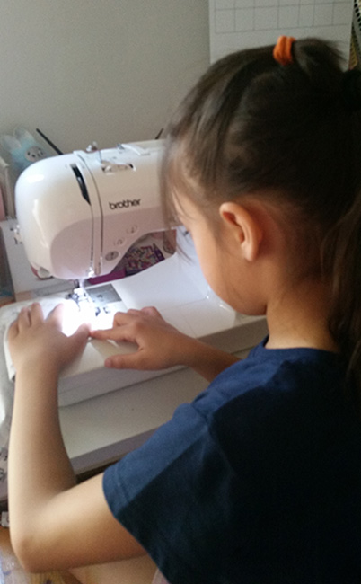 Tehya sewing scrunchies that she sold to raise funds to help restore sight.