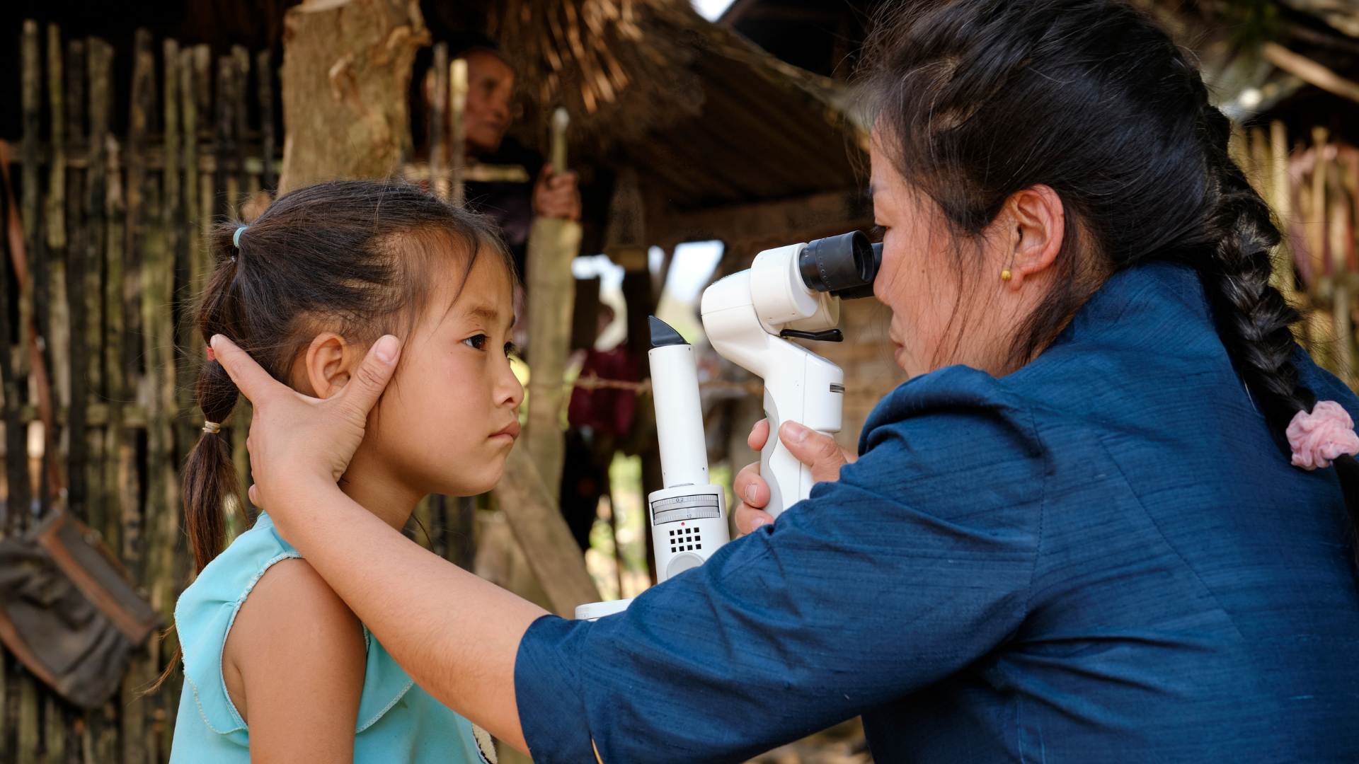 Chansouk having her eyes screened by an outreach worker trained by The Foundation