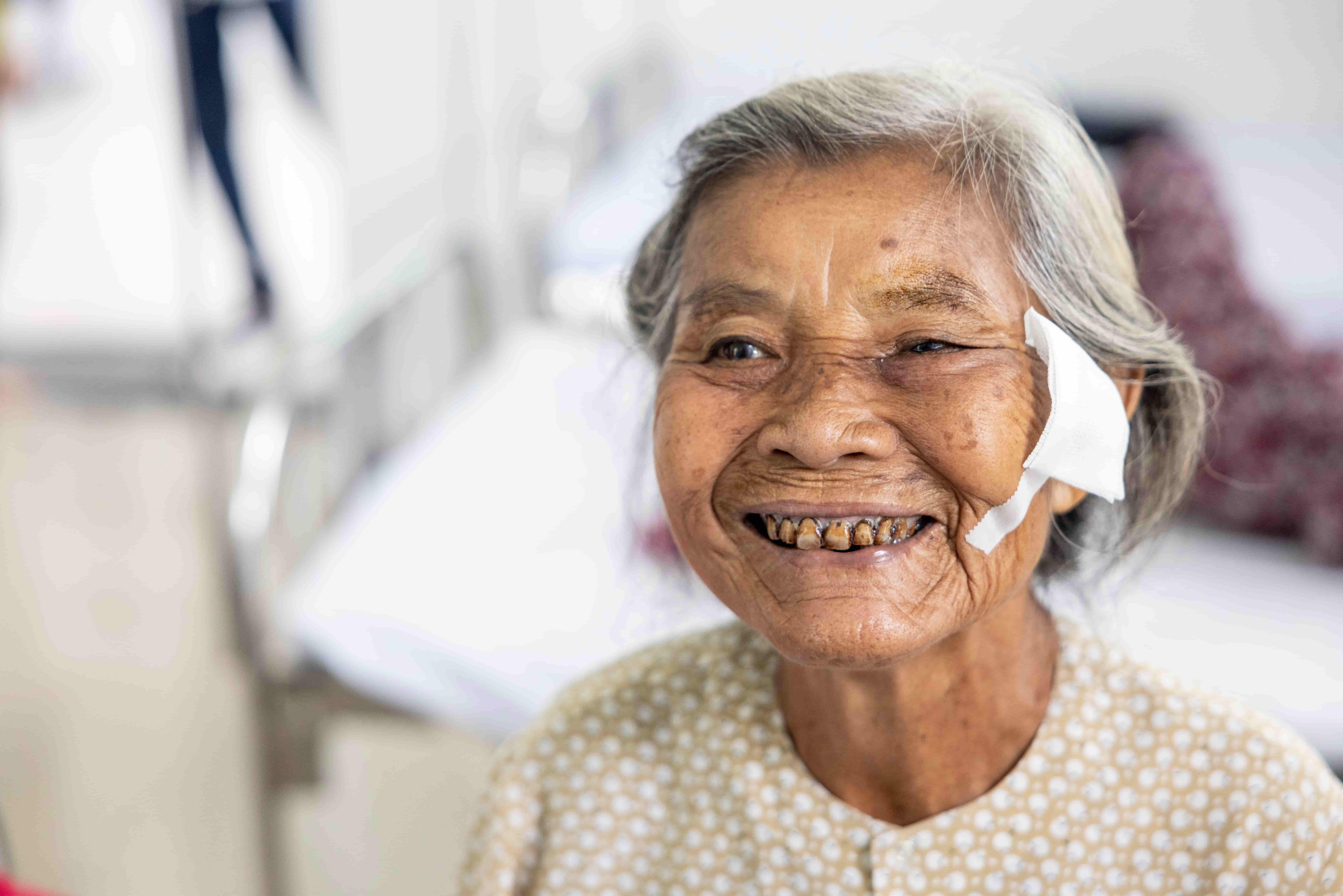 Tran Thi Den, 82, smiles as the patch comes off after cataract surgery – a simple procedure that restored her sight and independence.
