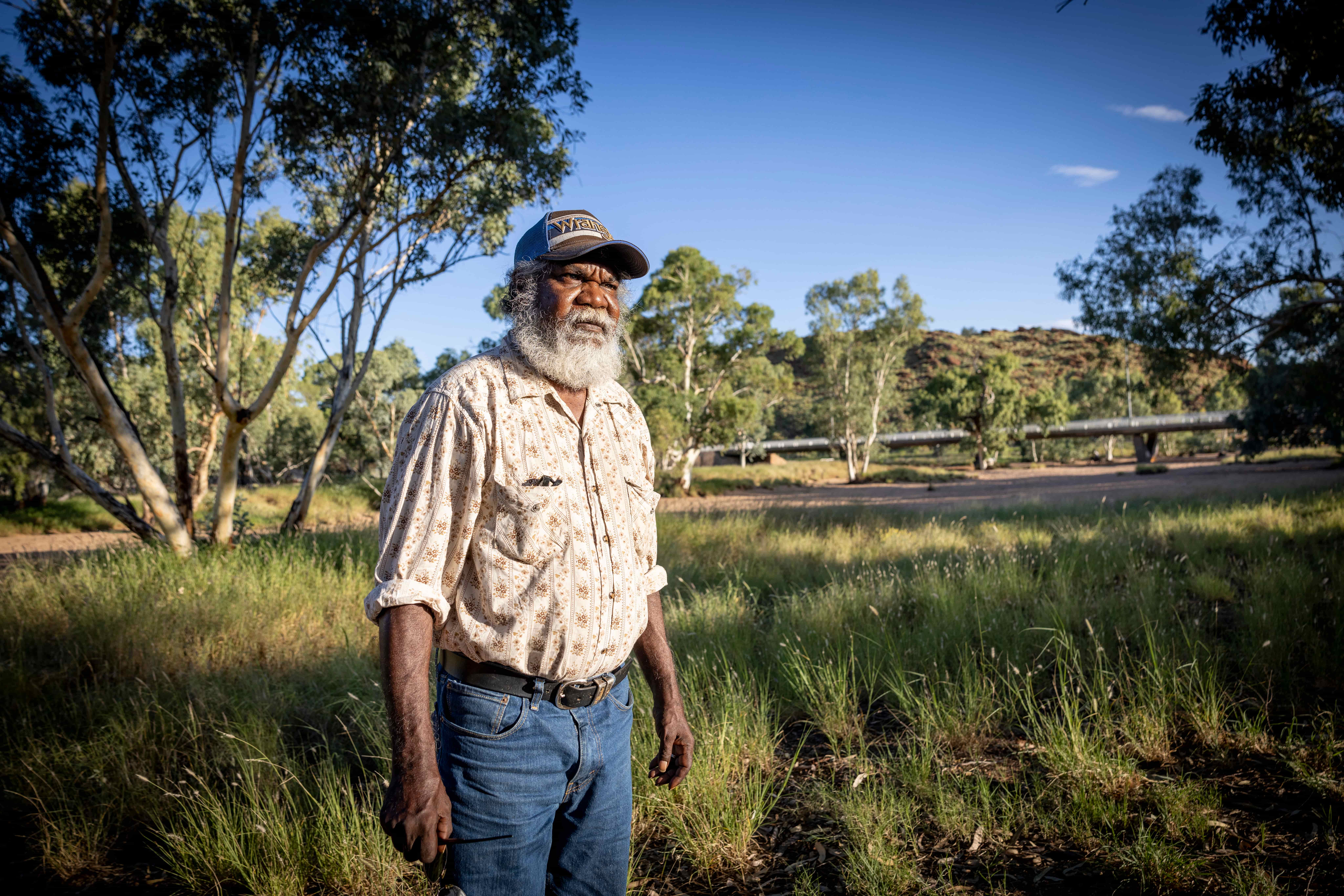 Jeffrey Foster walking across Warumungu Country in the Northern Territory, looking out over the land he cares for.