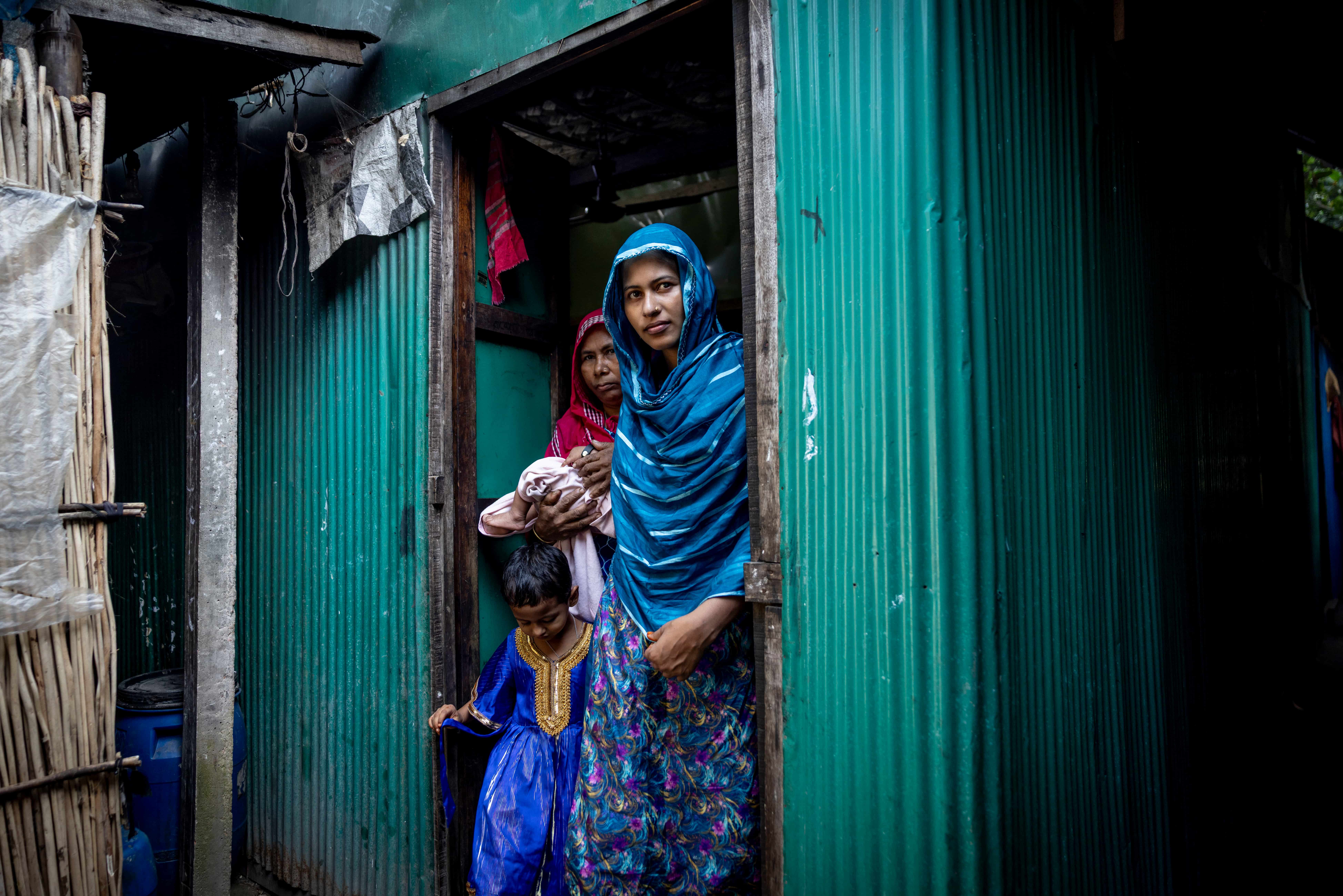 Parveen and her family walking outside their home in Bangladesh