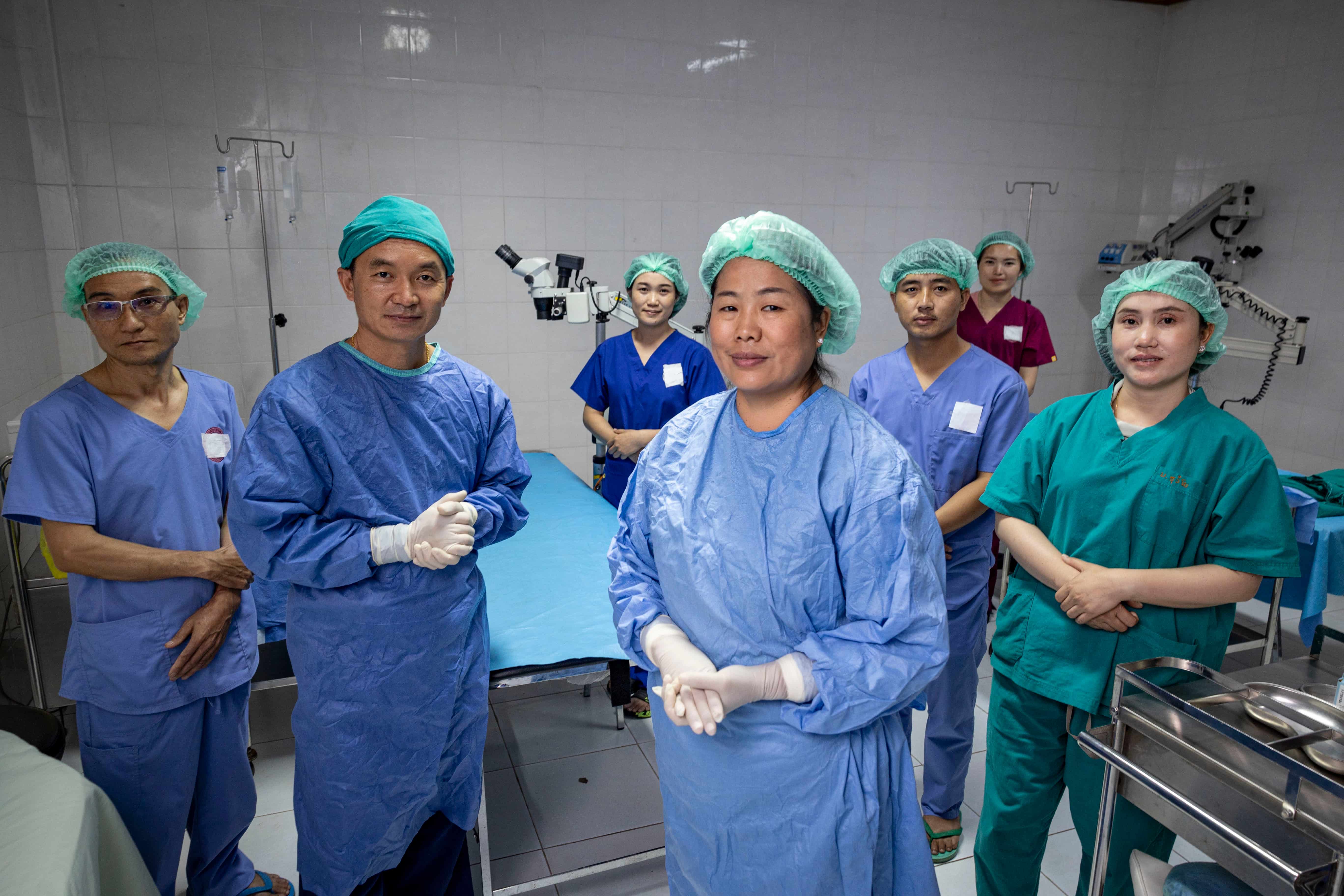 Dr Senglar Laosern and Dr Phetsamone Indara stand with their surgical team in the operating theatre at Oudomxay Provincial Eye Hospital, the centre where they conduct cataract and other eye surgeries for patients from remote villages.