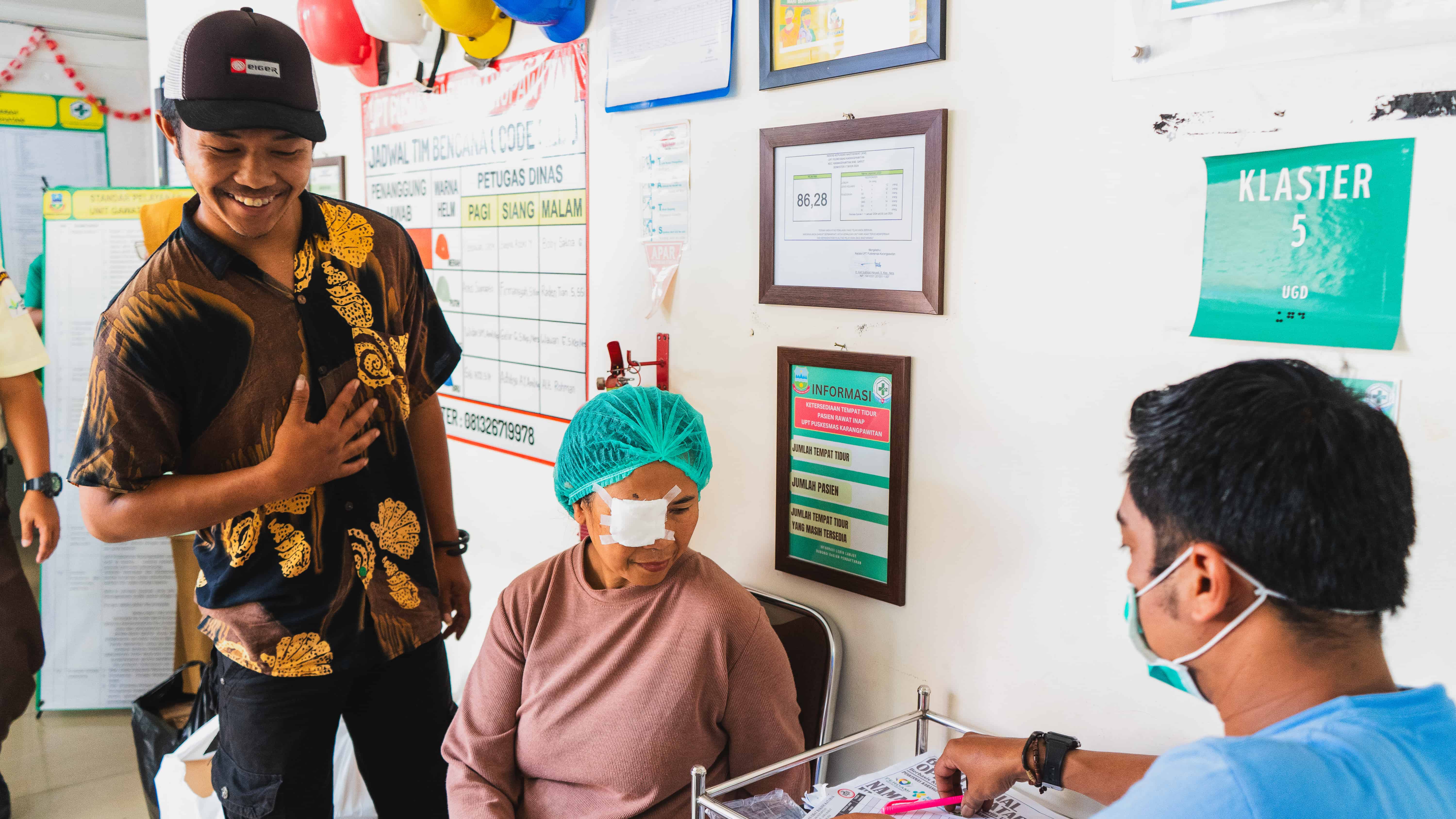 Kartini sits after cataract surgery in Garut District, Indonesia, with a protective eye patch in place. Following years of worsening vision, she received sight-restoring surgery supported by The Fred Hollows Foundation, helping her begin the journey back to caring for her family and living more independently.
