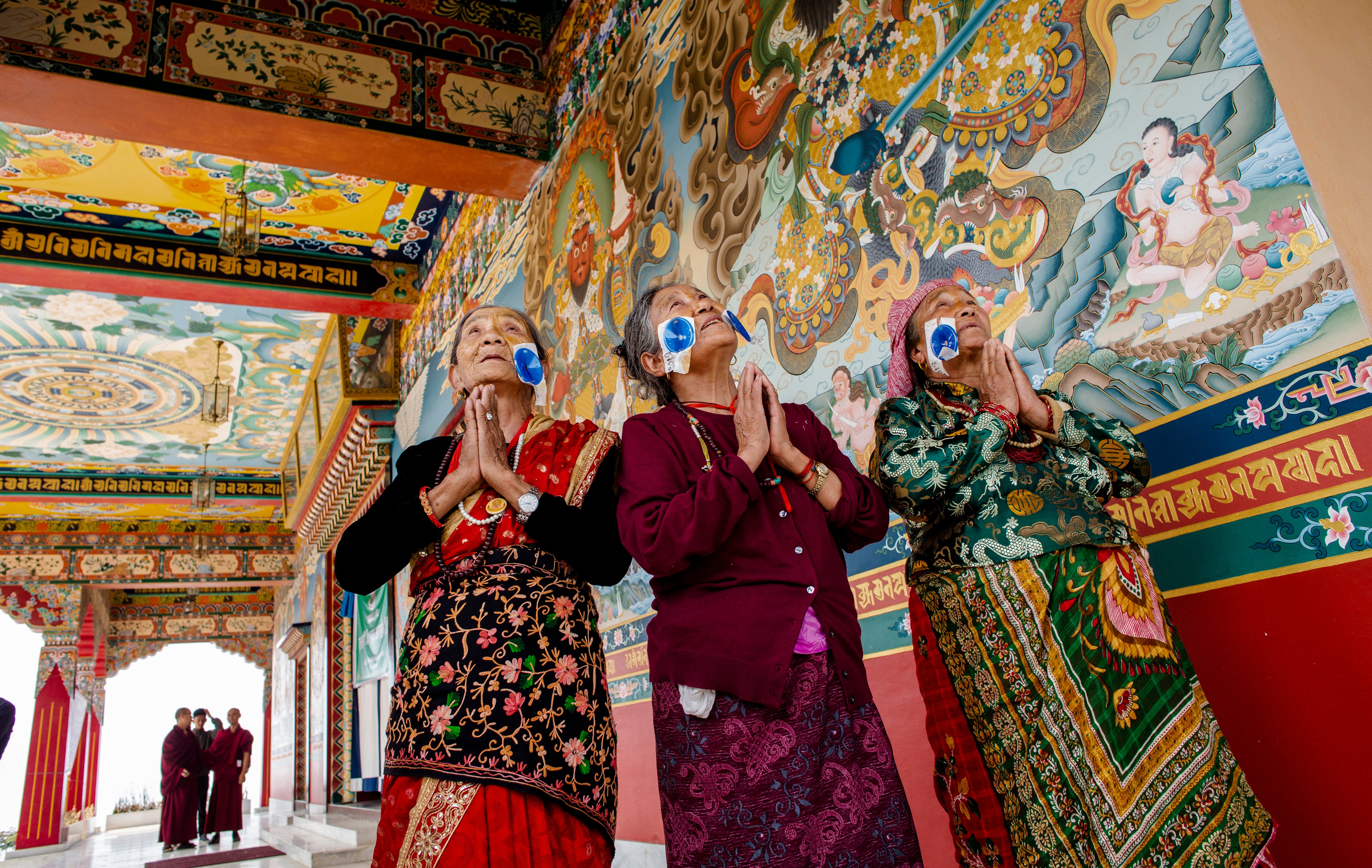 Three female cataract patients say thank you after surgery at an eye camp at a Kathmandu monastery.