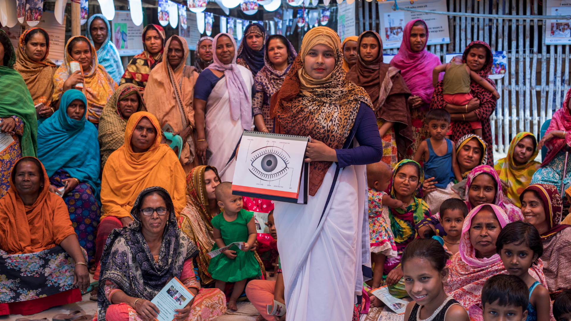 Nasrin in Bangladesh showing an eye chart to a group of children