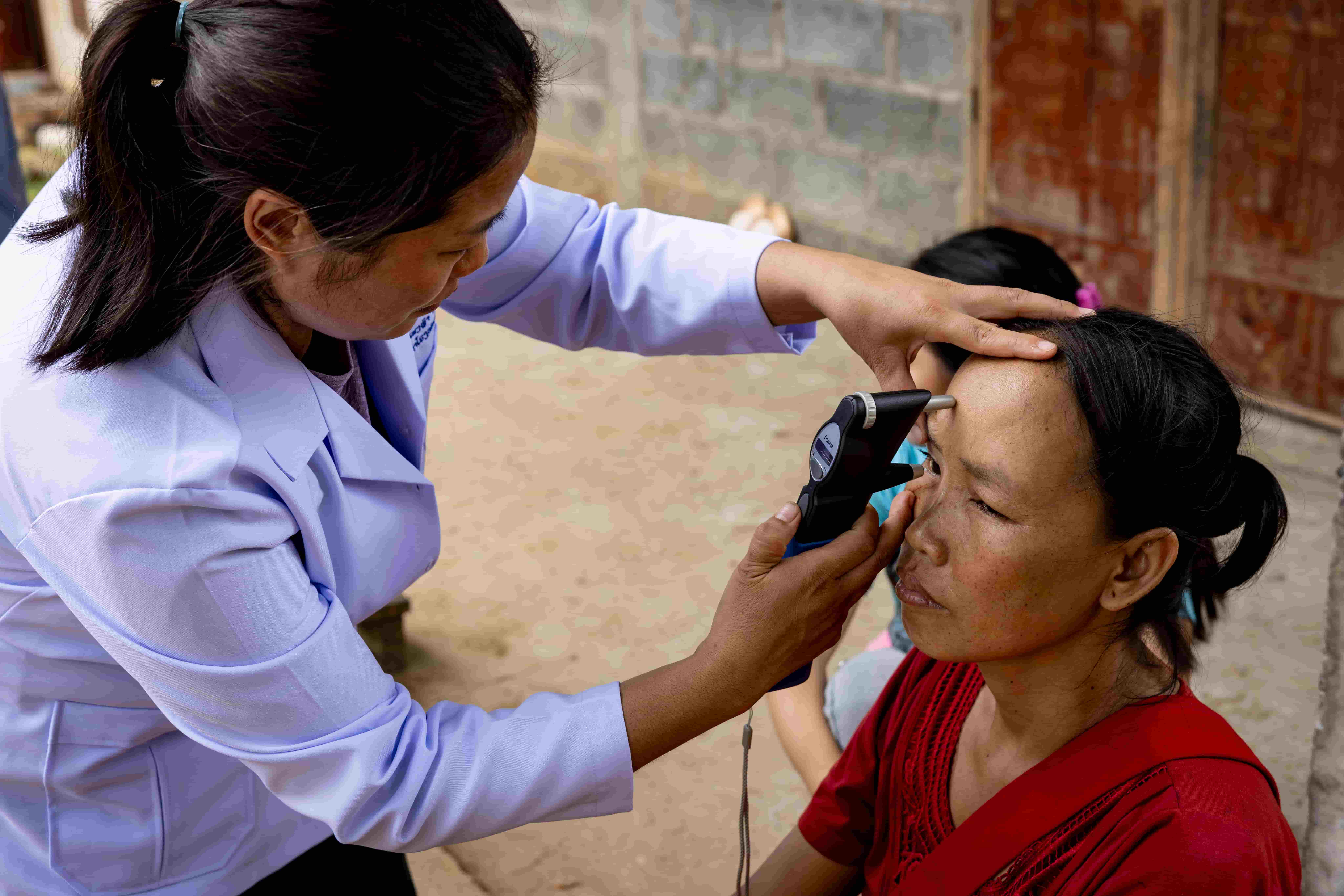 Dr Senglar Laosern conducts an eye screening for Lien at her home in Oudomxay, Laos, as part of The Fred Hollows Foundation’s outreach program.