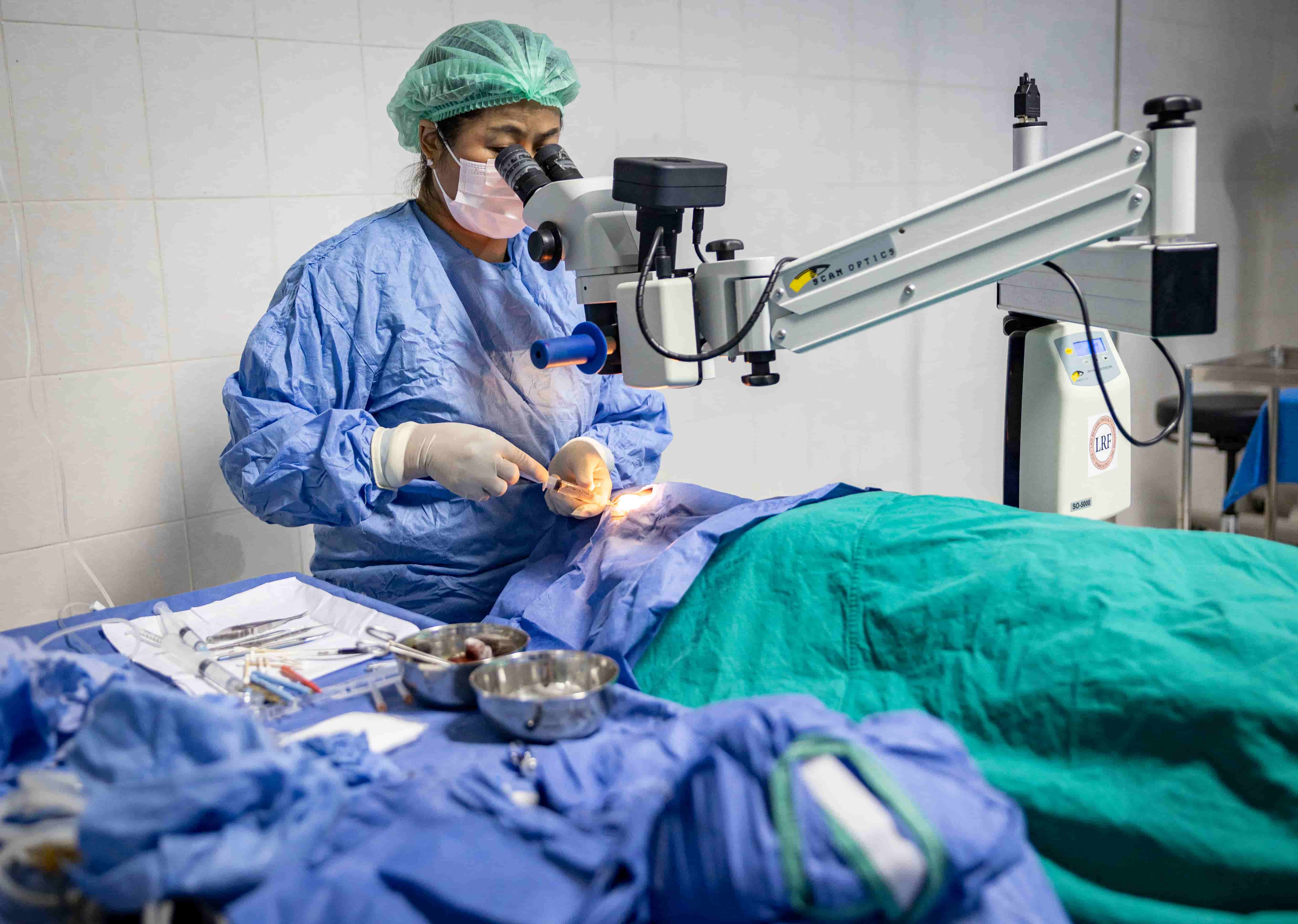 A trained Fred Hollows Foundation doctor, Dr Senglar, completes surgery on a patient in Laos.