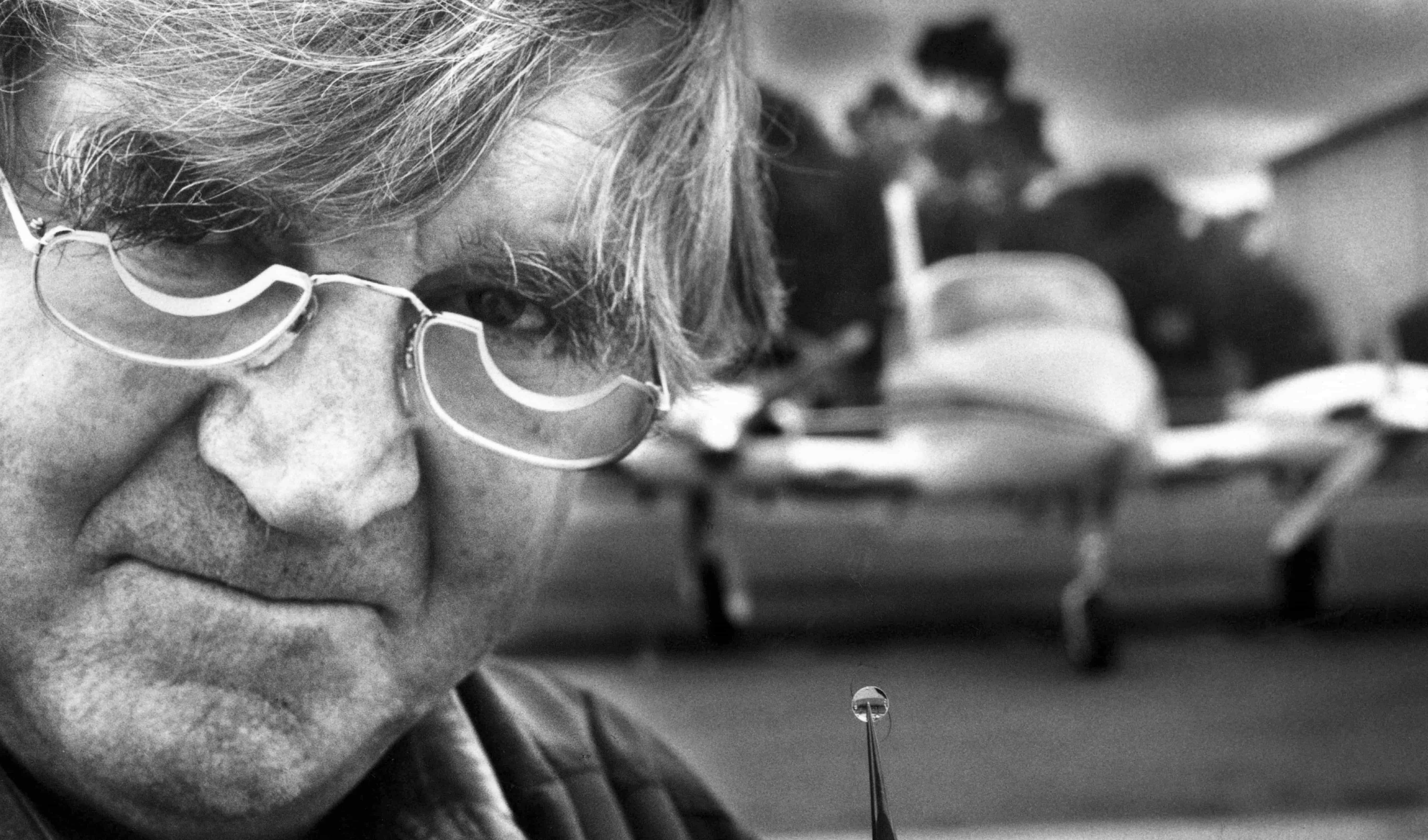 Professor Fred Hollows holds an intraocular lens made from PMMA perspex, the same material used in aircraft windows.