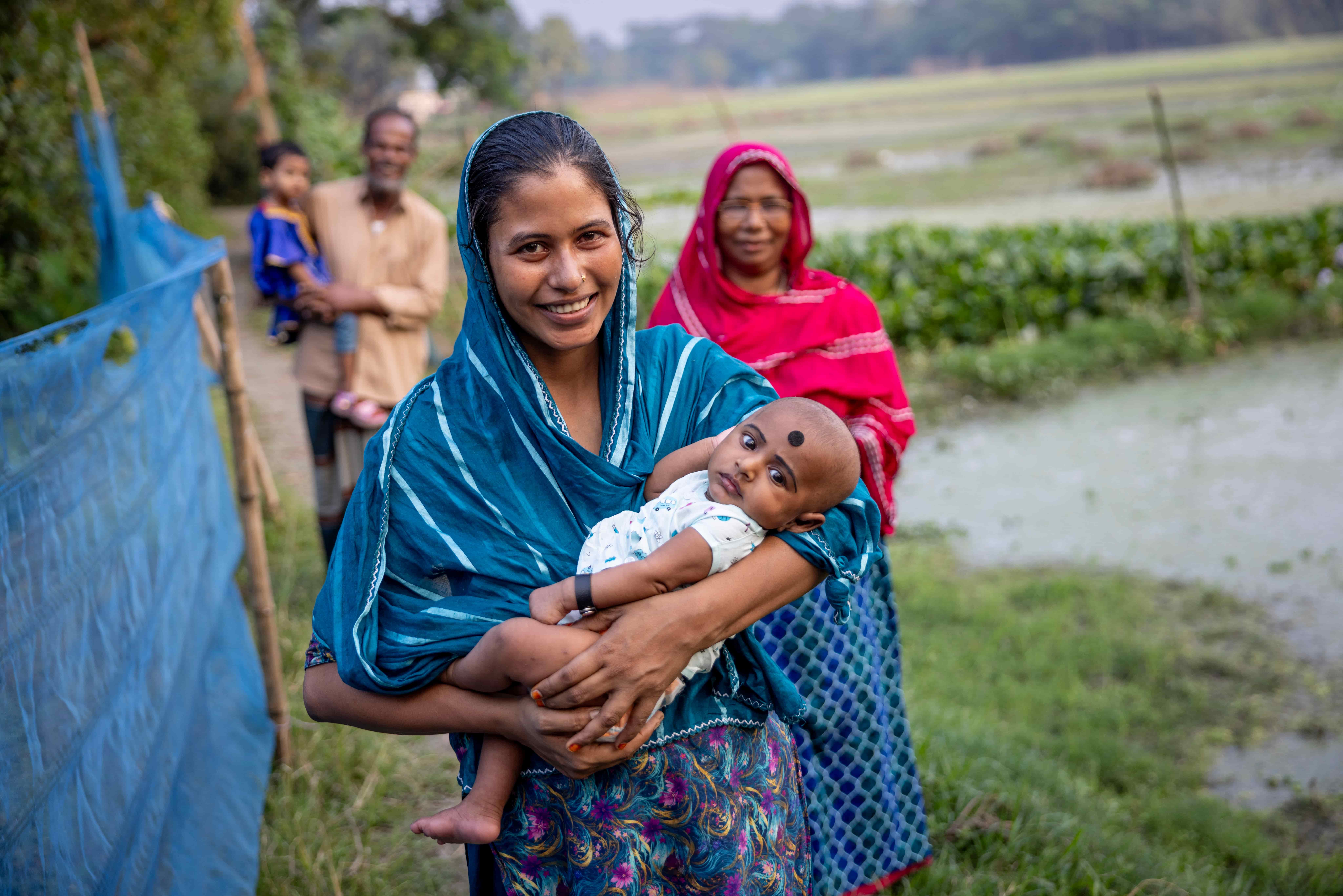 Parveen holding her baby at her home, days after surgery