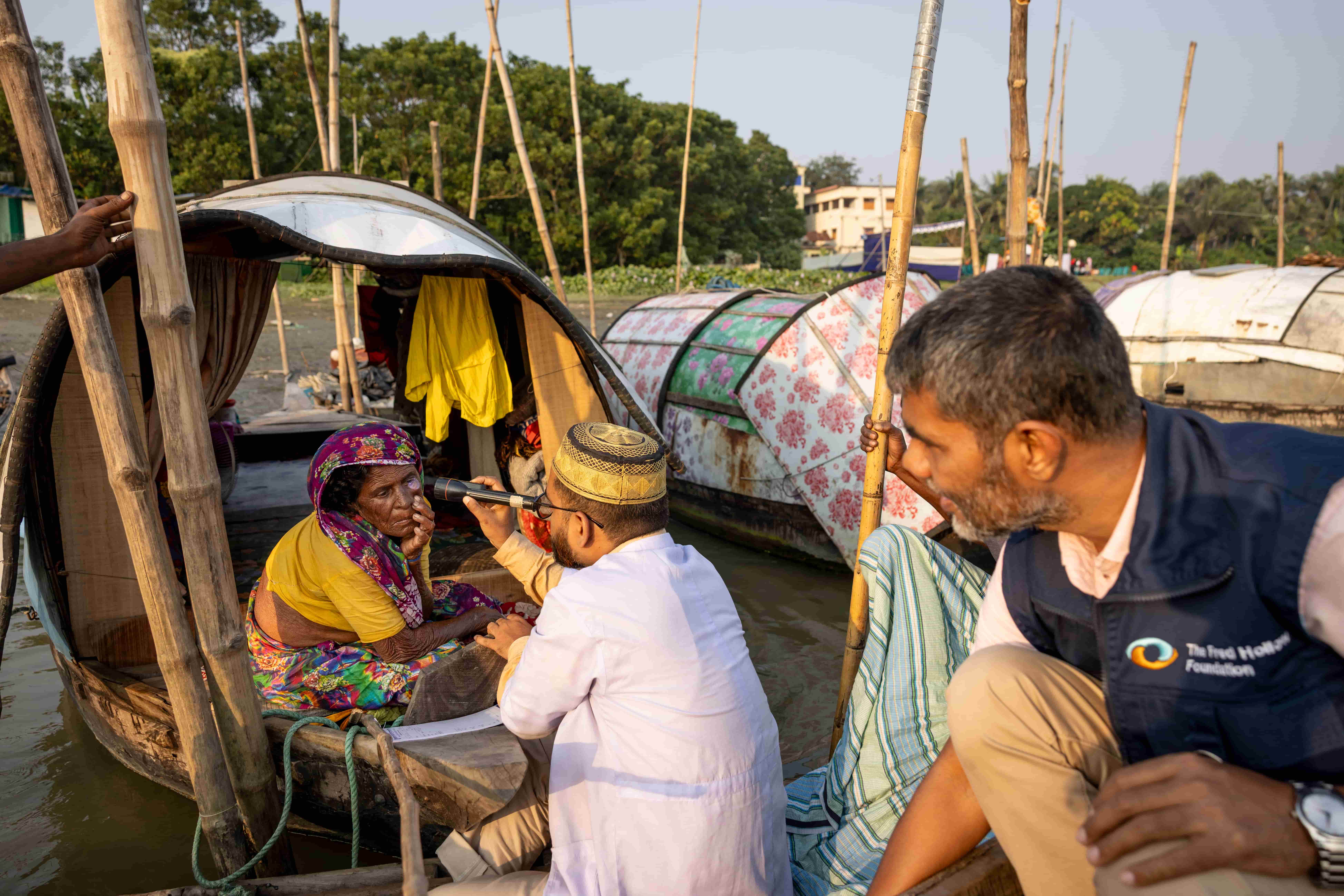 Eye health workers travel by boat to reach the Bede community in Chandpur, screening for cataracts and connecting patients with treatment. Outreach services like this help bring eye care closer to people who face barriers accessing hospitals.
