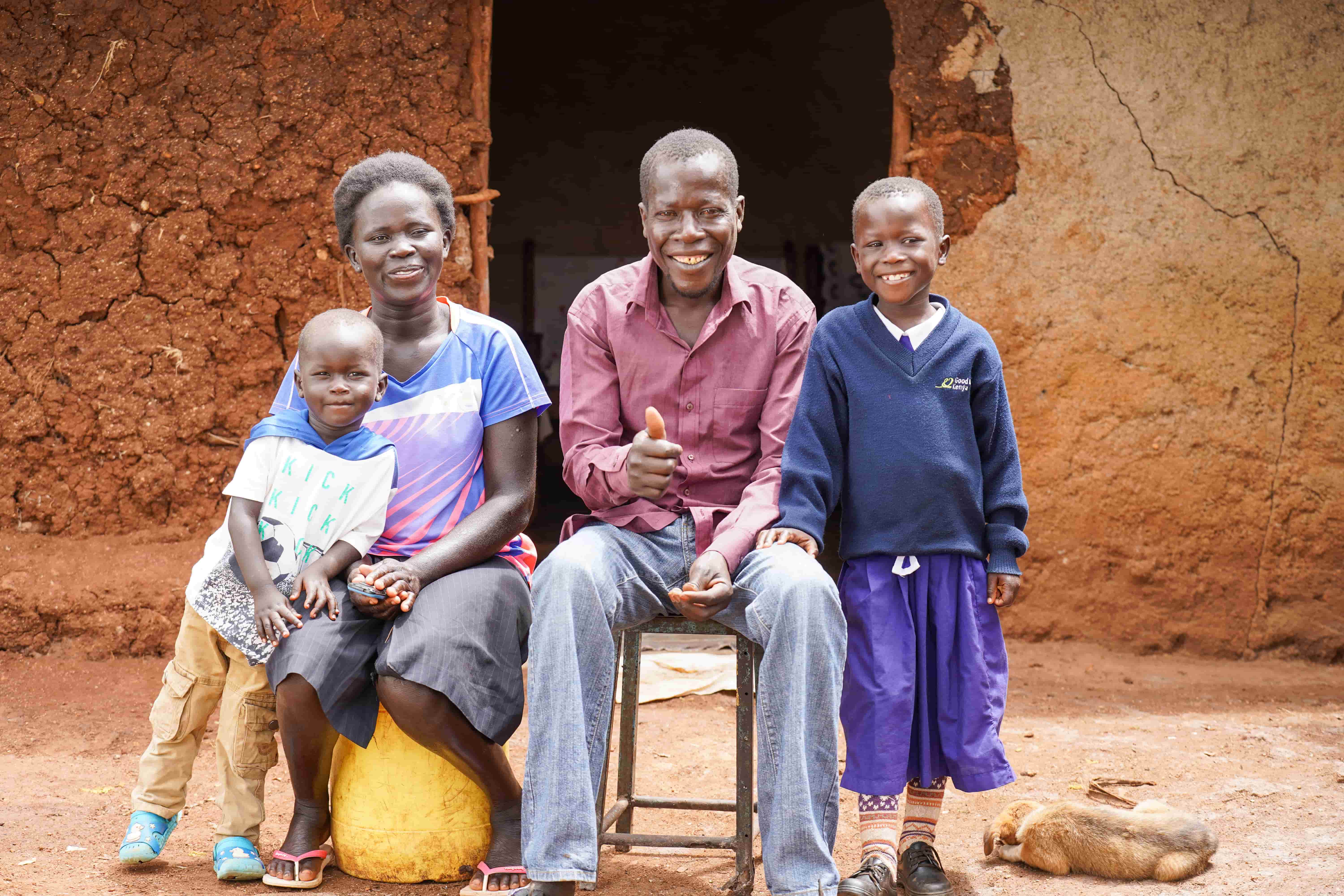 A family - Eveline, Boniface, Ruth and Vincent - standing out the front of their home in Kenya, one year after eye surgery.