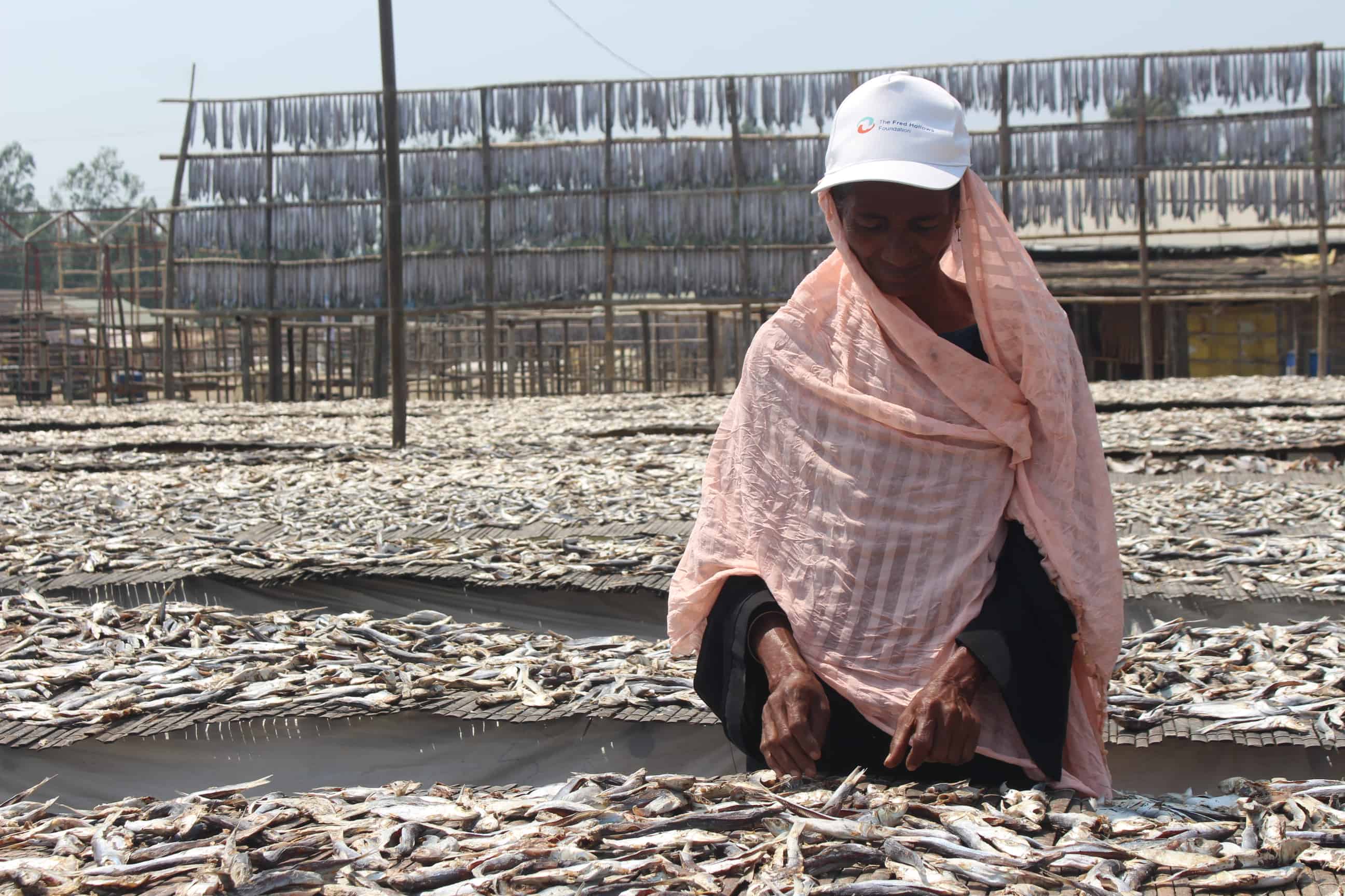 Bulu Ara, 55, processes dried fish at a market in Cox’s Bazar, working outdoors in the coastal heat.