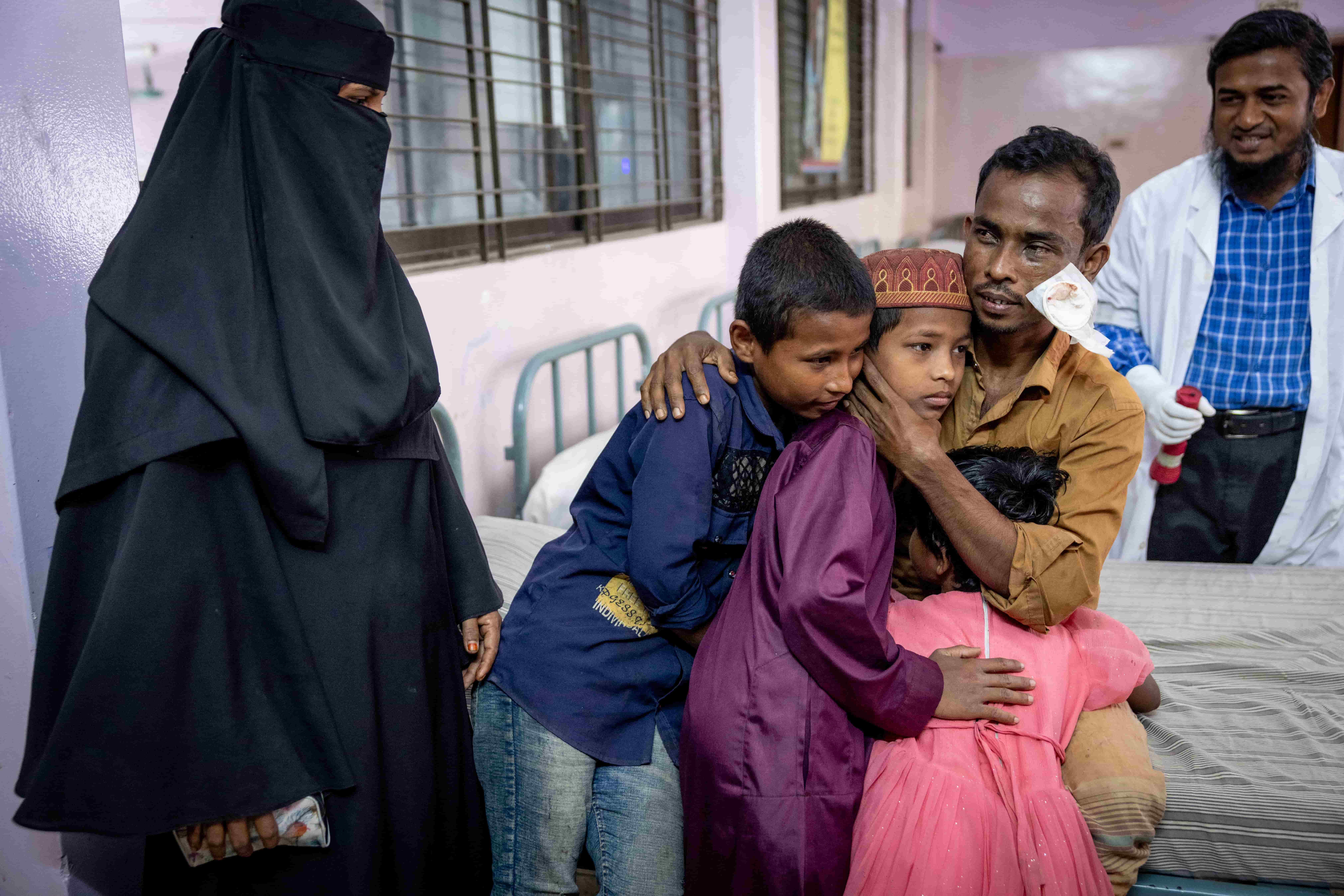 Obaidul embraces his three children after cataract surgery in Cox’s Bazar, his eye patch removed.