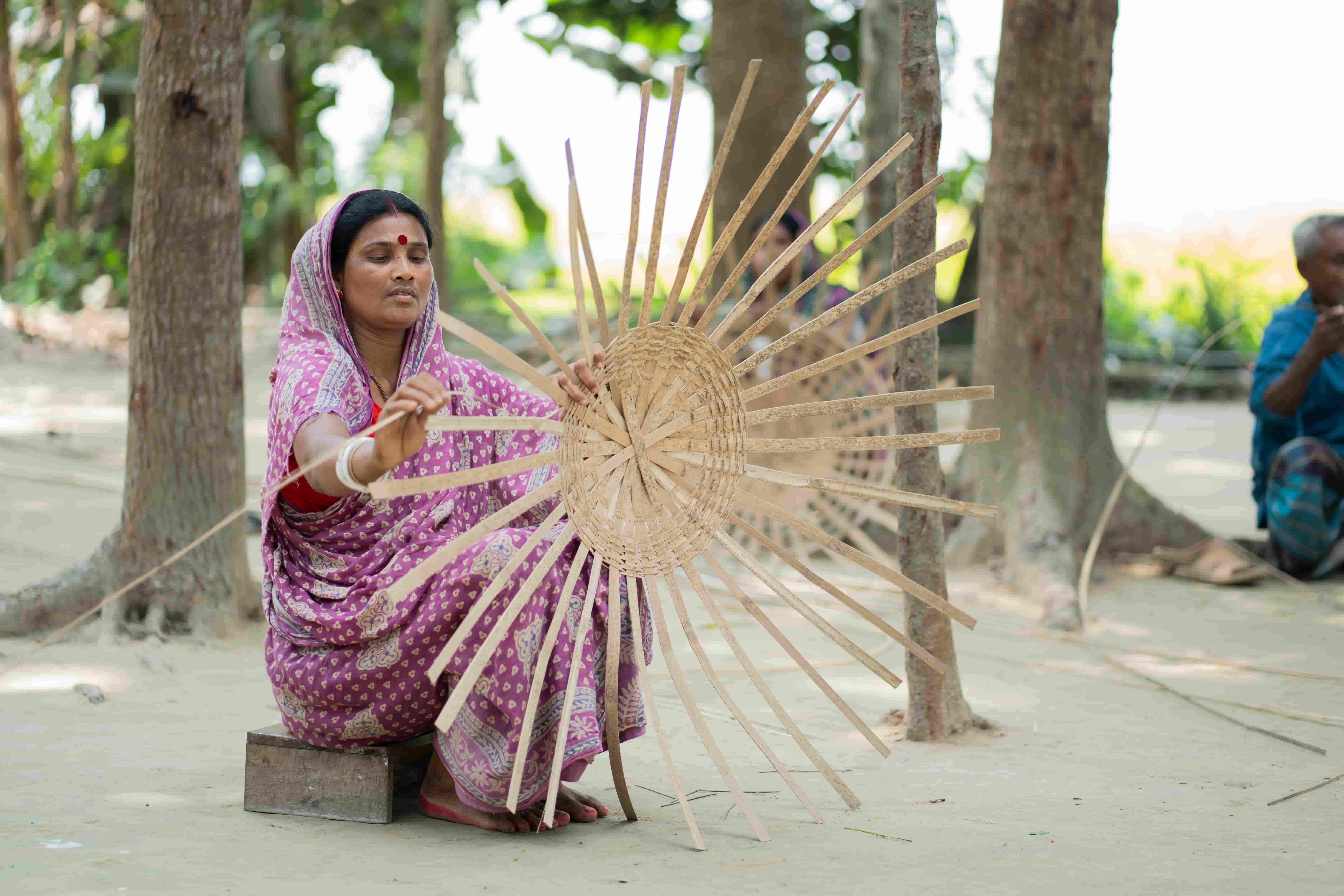 A woman in Bangladesh weaving baskets, representing how preventing avoidable blindness enables people to remain employed and productive.