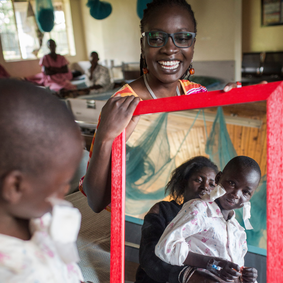 Seven-year-old Nabiritha looks into a mirror, seeing her own face clearly for the first time after sight-restoring surgery.