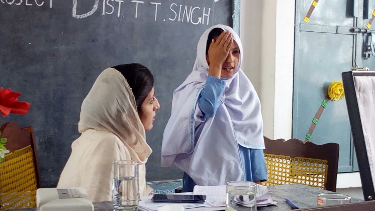 A student gets their vision checked at a school eye screening.