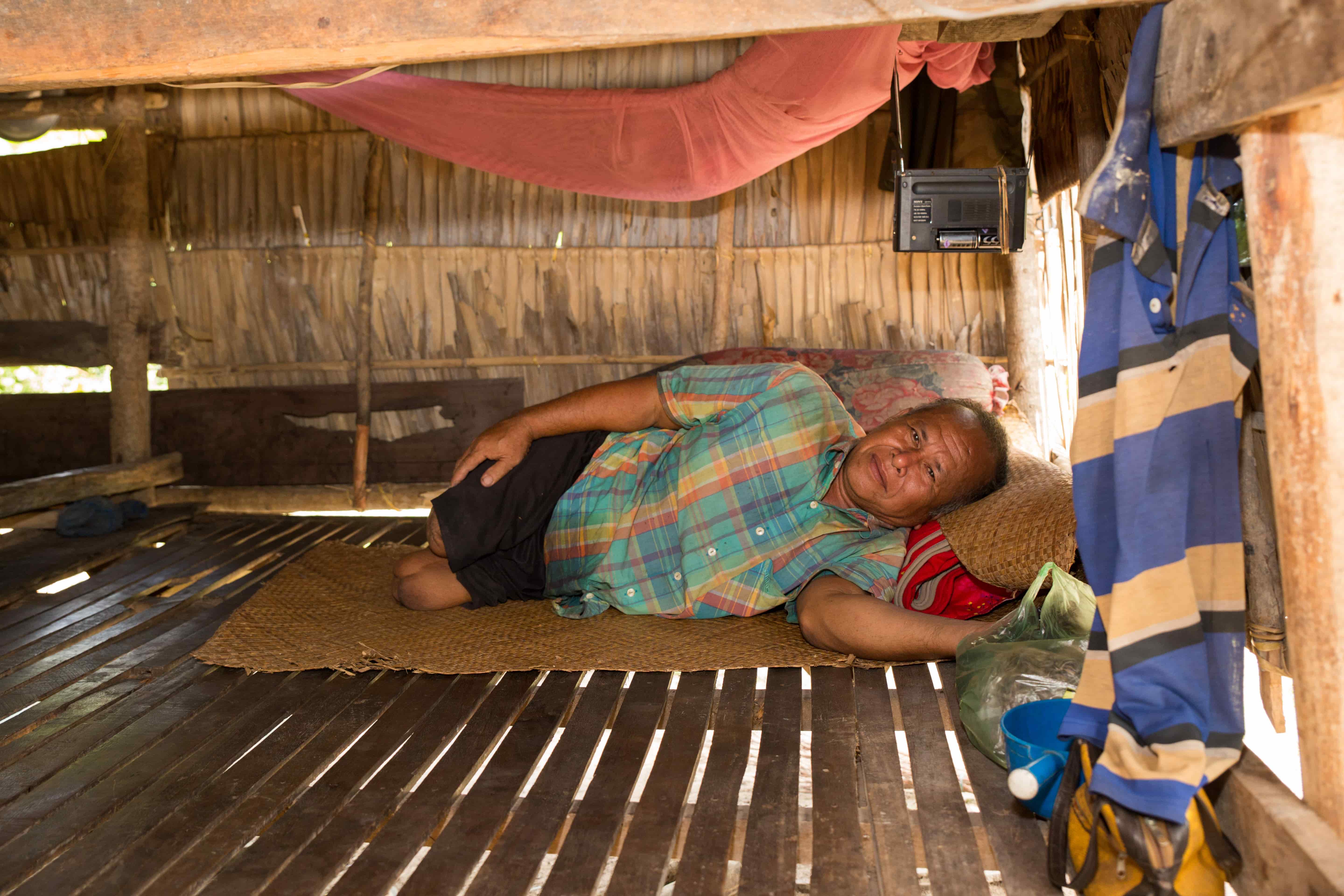 Chan Ngin rests at home, a Cambodian landmine survivor who lost both legs.