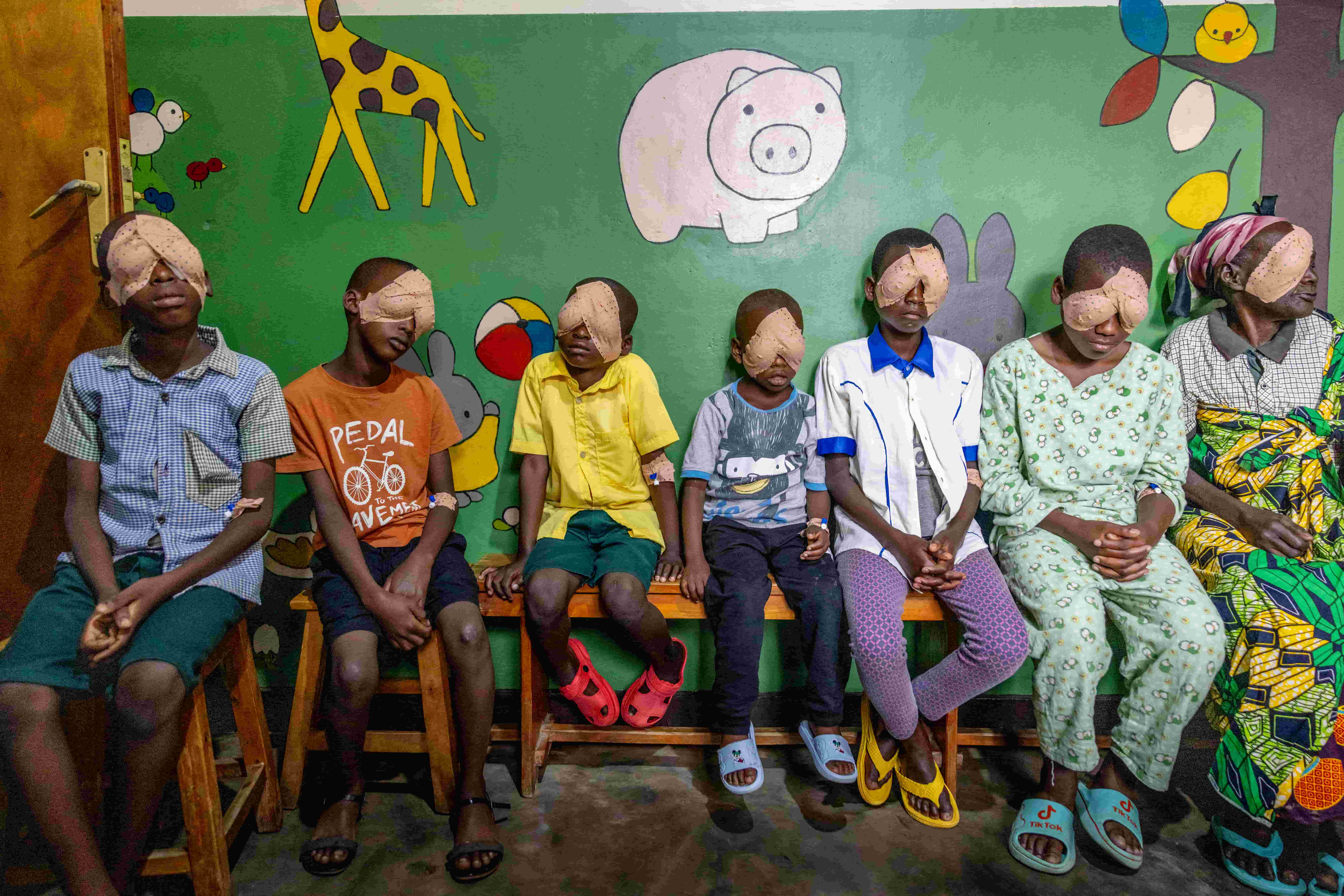 Children in Rwanda stand together with eye patches after receiving sight-restoring surgery supported by The Fred Hollows Foundation.