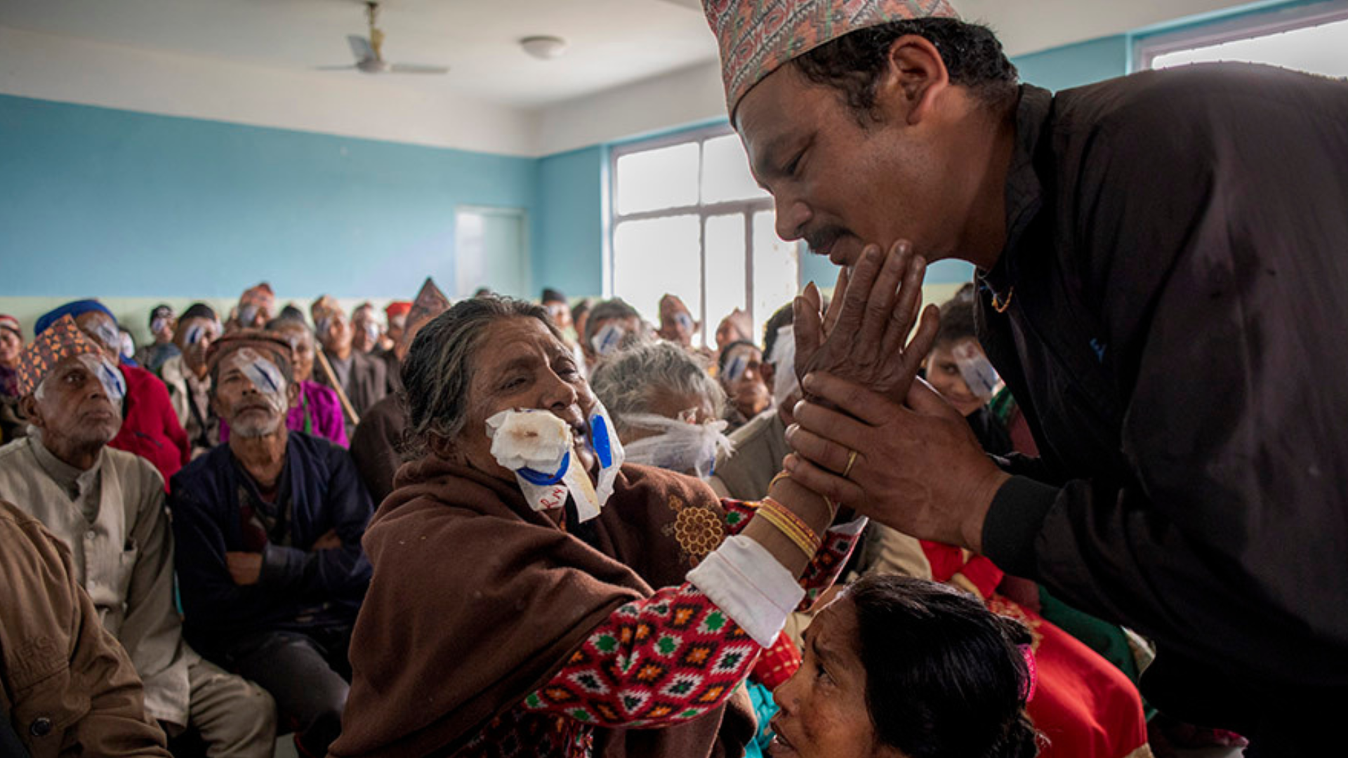 A Nepalese woman reaching her hand out to a health worker in a gesture of gratitude