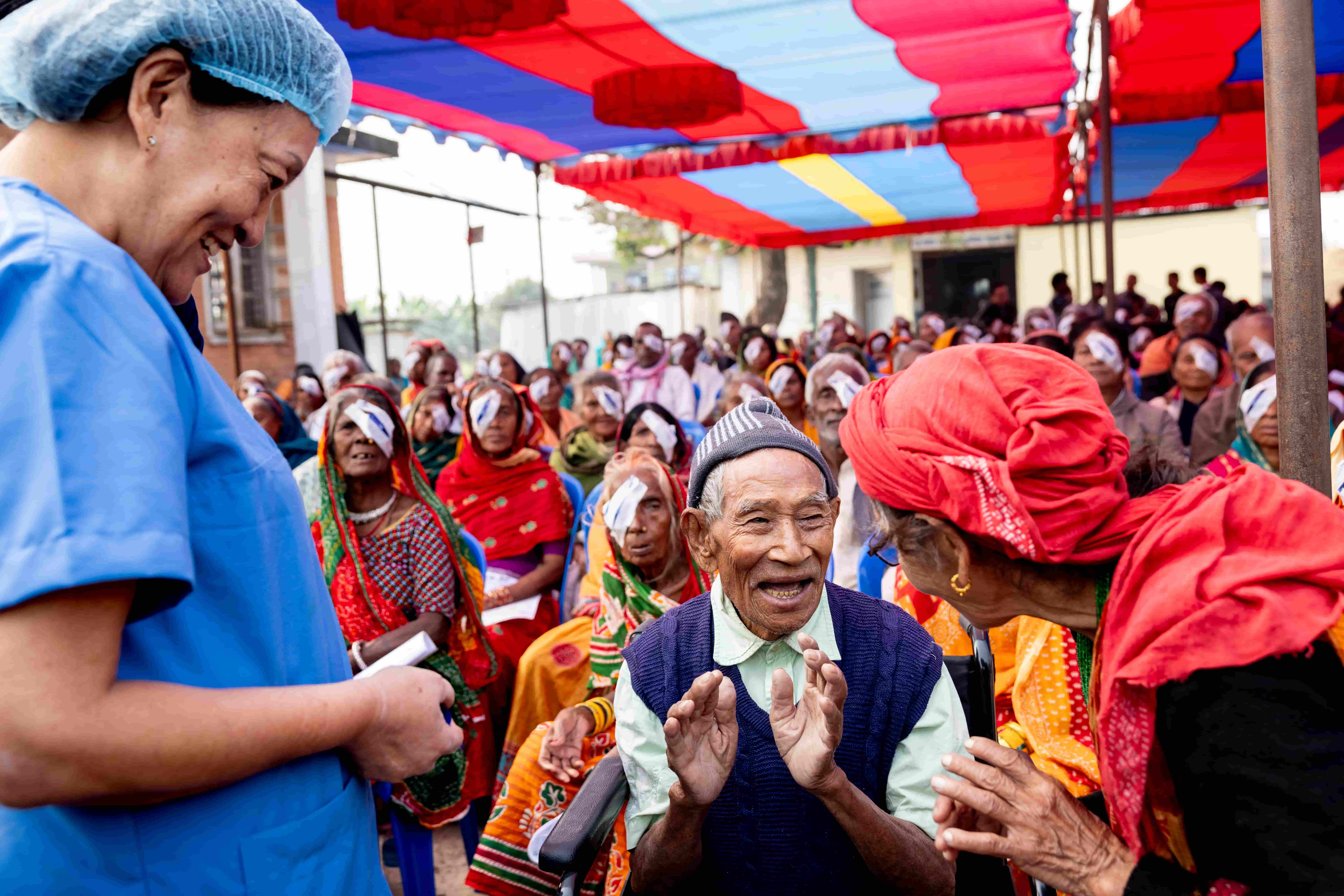 Krishna, 82, hugs his wife Mitthu and great-granddaughter Renish after his cataract surgery patch is removed, celebrating the restoration of his vision.