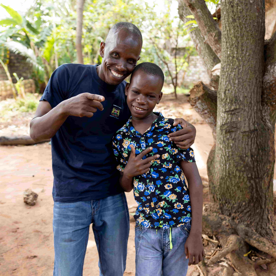 Mbaruku stands with Hemedi, the Community Health Worker who supported him in getting cataract surgery at Kwale Eye Centre.
