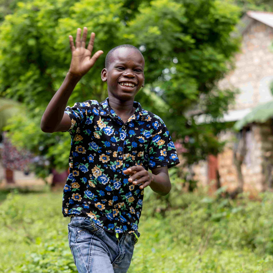 Years after his sight-restoring surgery, Mbaruku runs and plays football with friends, back to his normal life.